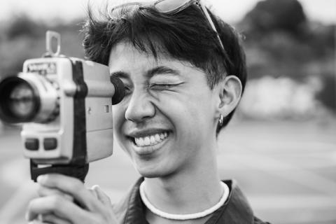 Asian woman holding vintage video camera